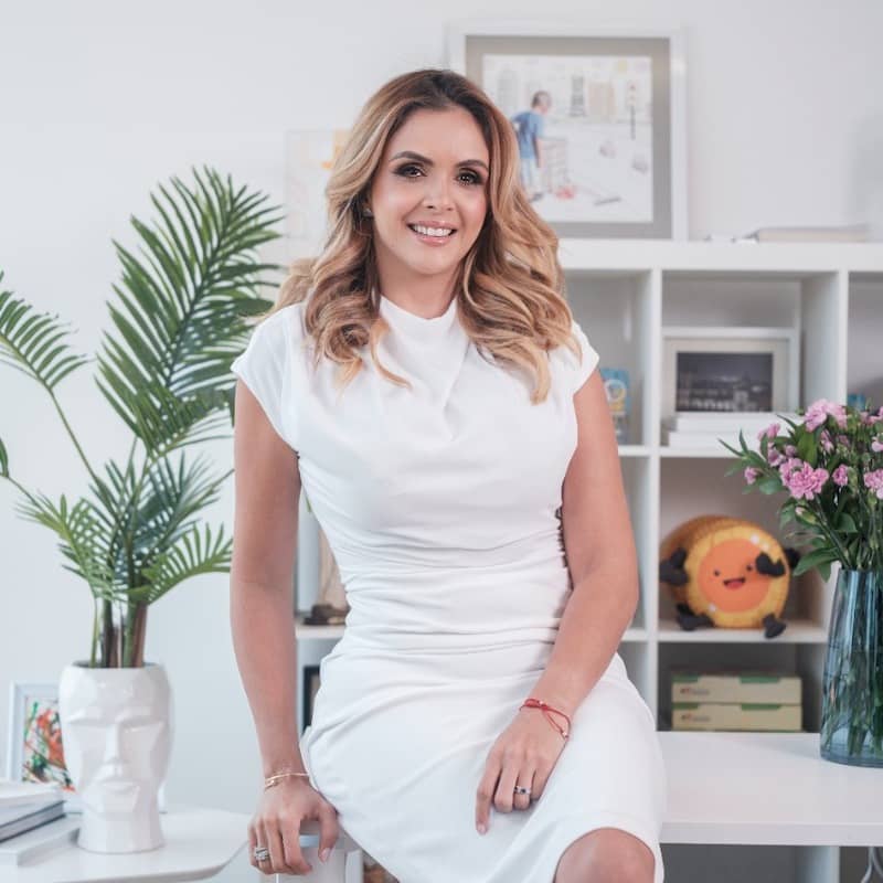 Portrait of María Claudia García Navarro in white dress against office background